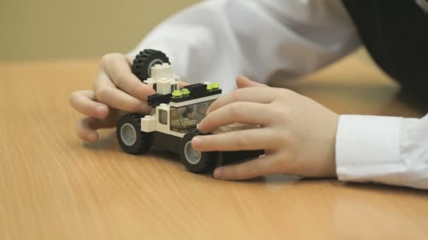 Boys hands collect a car from designer - Záběry, video