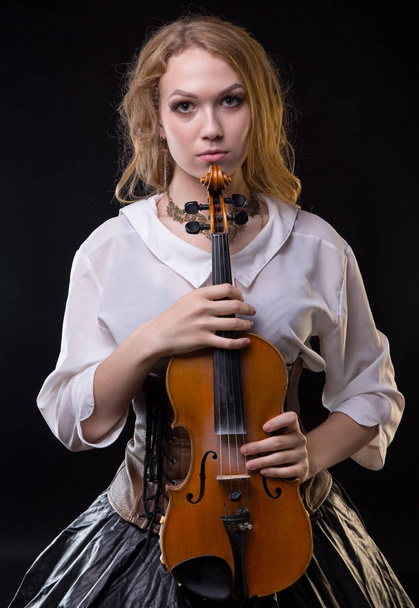 Blond young girl holding the violin - Fotó, kép