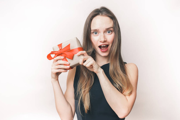 Surprised woman demonstrate gift, cute happy girl with a gift in hands - Foto, Bild