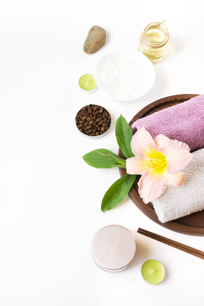 Spa setting of towel, flower, coffee on white background with copy space. - Photo, Image
