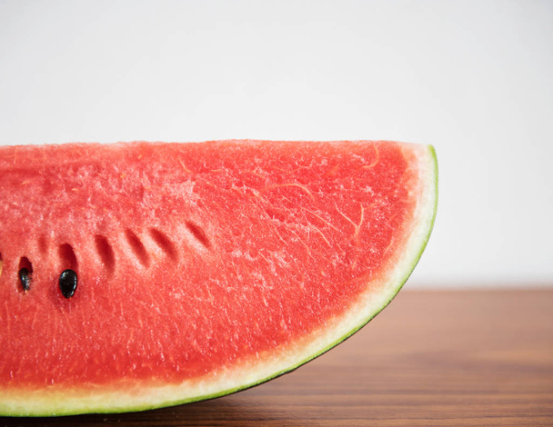 Slice of watermelon on brown table background - Φωτογραφία, εικόνα