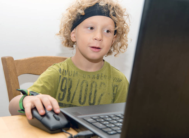 Ritratto di un bambino biondo che usa un computer portatile
 - Foto, immagini