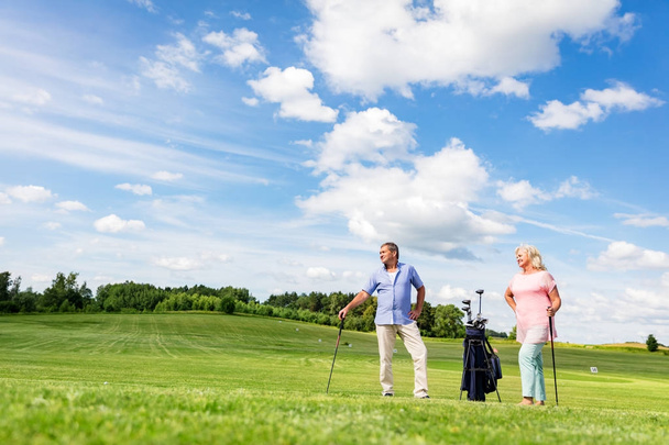 Ανώτερος ζευγάρι απολαμβάνει το παιχνίδι γκολφ. - Φωτογραφία, εικόνα