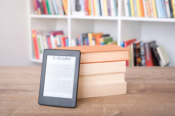 E-boek lezer op een stapel boeken - Foto, afbeelding