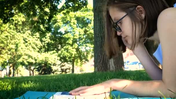 girl reading on a grass - Filmati, video