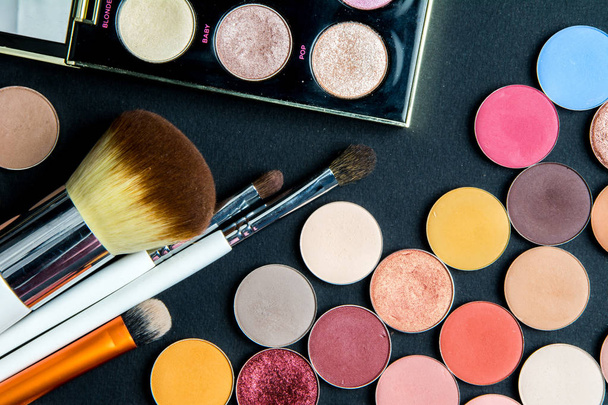 Make-up colorful eyeshadow palettes isolated on black background. View from above. Brushes kit make up set, soft makeup brushes and maskara on black background - Photo, Image