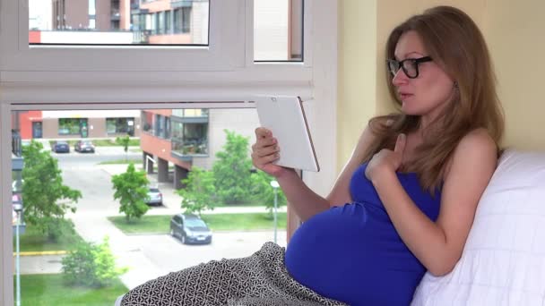 Mujer embarazada tienen video chat conversación tableta en línea
 - Metraje, vídeo