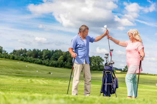 Старшая пара выбирает оборудование для игры в гольф
. - Фото, изображение