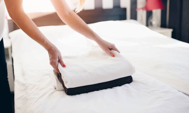 Hotel empregada colocando toalhas limpas e frescas na cama
 - Foto, Imagem