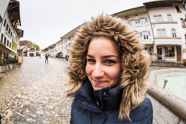 A girl in a blue coat in Gruyeres in Switzerland - Fotografie, Obrázek