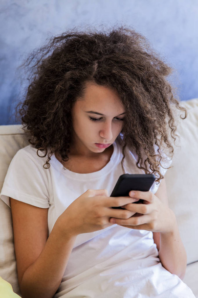 巻き毛の十代の少女は、sms メッセージを書き込みます - 写真・画像