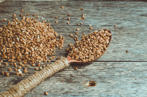 Scattered buckwheat and a spoon full of buckwheat - Фото, зображення