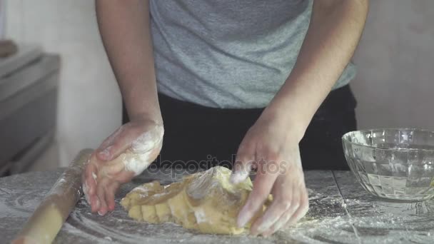 Baker kezek dagasztás tészta a liszt, a tábla, lassú mozgás. - Felvétel, videó