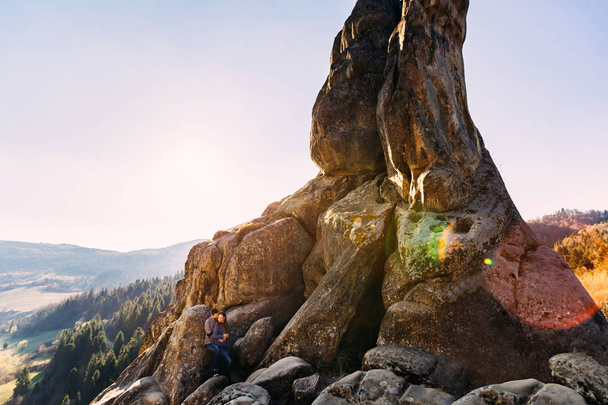 красивая пара обнимается на скалах в захватывающем пейзаже
  - Фото, изображение