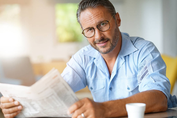 man with eyeglasses reading newspaper - Foto, afbeelding