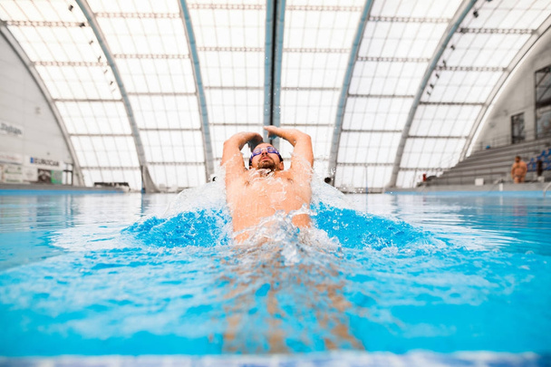 Man swimming in an indoor swimming pool. - Valokuva, kuva