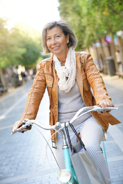 senior woman riding city bike - Zdjęcie, obraz