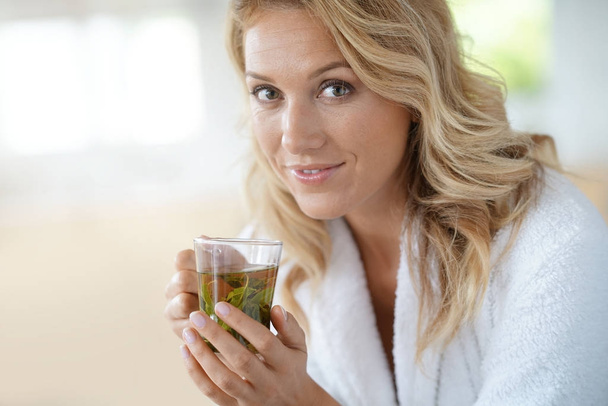 woman in bathrobe drinking infusion - Photo, image