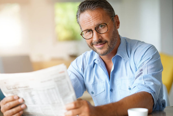 man with eyeglasses reading newspaper - 写真・画像