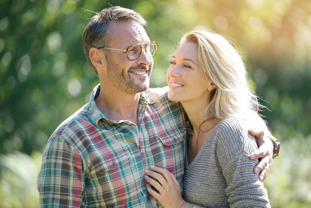 Portrait of mature couple enjoying sunny day in nature - Foto, afbeelding