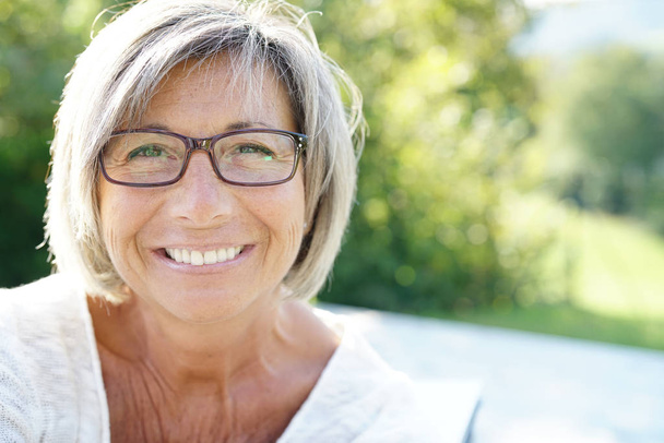 Frau mit Brille entspannt sich draußen - Foto, Bild