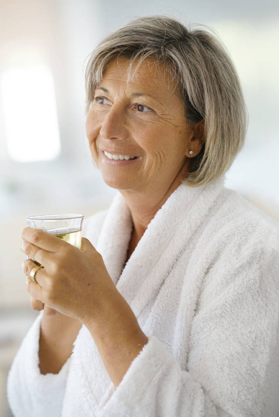 woman in bathrobe drinking - Фото, изображение
