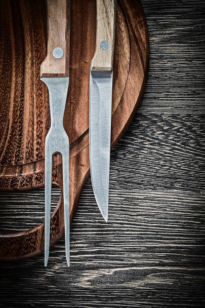 Meat fork knife wooden chopping board on wood background - Foto, afbeelding