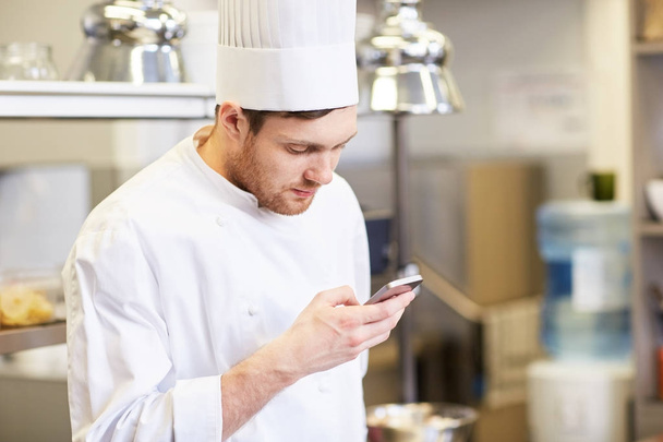 chef cook with smartphone at restaurant kitchen - Фото, изображение