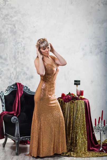 Красива дівчина в золотій сукні з короною
 - Фото, зображення