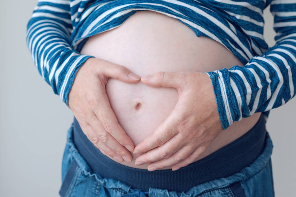 Terhes nő, megható és dörzsölés a hasát - Fotó, kép