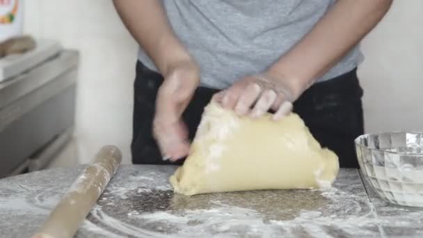 Dłonie dziewczyny wyrabiania ciasta w mąki na stole - Materiał filmowy, wideo