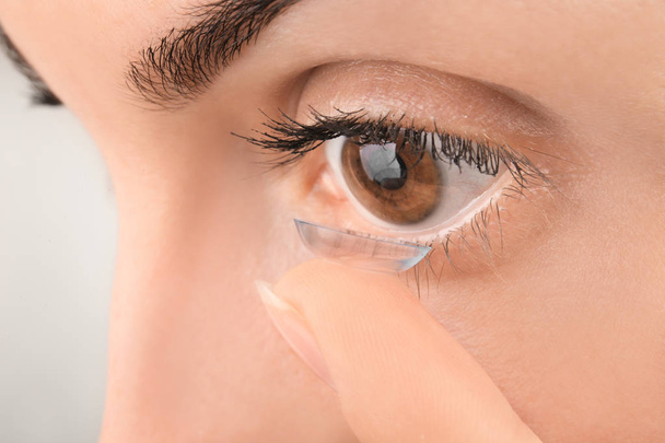 Young woman putting contact lens, closeup - Foto, immagini