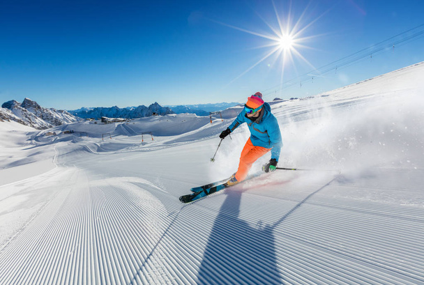 Młody mężczyzna narciarz działa w dół stoku w alpejskich gór - Zdjęcie, obraz