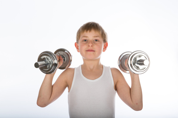 Young boy exercising with two dumbbells - 写真・画像