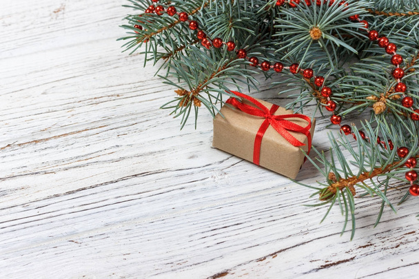 Cadeaux de Noël ou Nouvel An enveloppés dans du papier de couleur naturelle et décorés avec des brindilles traditionnelles de Noël et de sapin sur un fond blanc
 - Photo, image