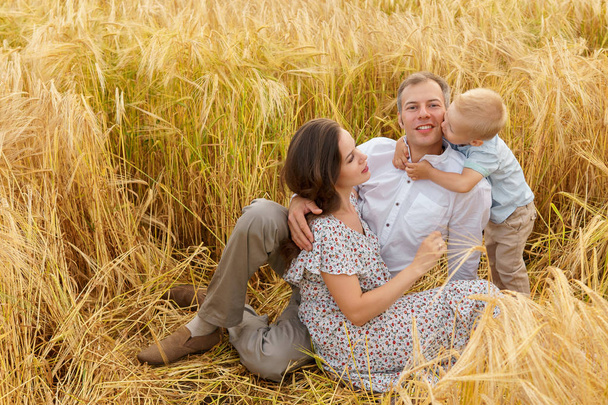 Famille assise sur l'herbe dans un champ de blé
 - Photo, image