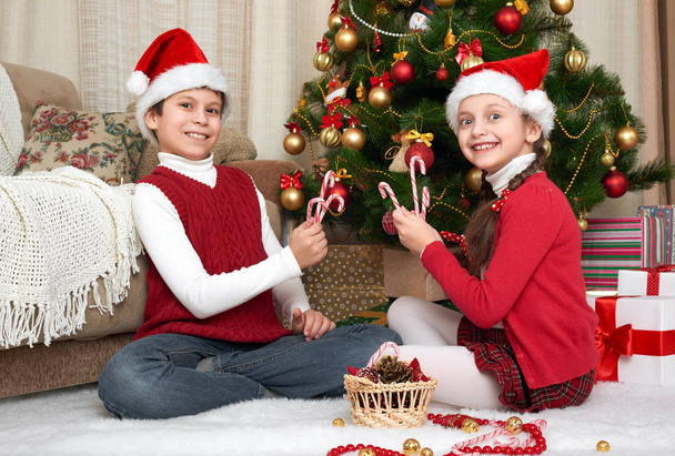 Criança em santa chapéu se divertindo e brincando, decoração de Natal em casa, emoção feliz, conceito de férias de inverno
 - Foto, Imagem