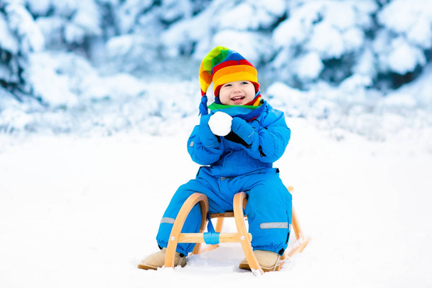 Boy on sleigh ride. Child sledding. Kid with sledge - Fotó, kép