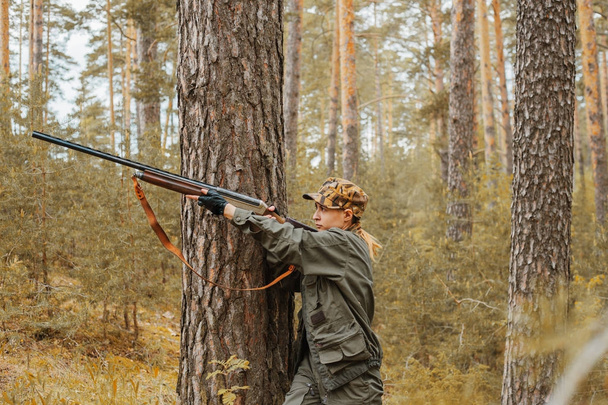 Nő vadász az erdőben. Őszi vadászidény. Szabadtéri sportok. - Fotó, kép