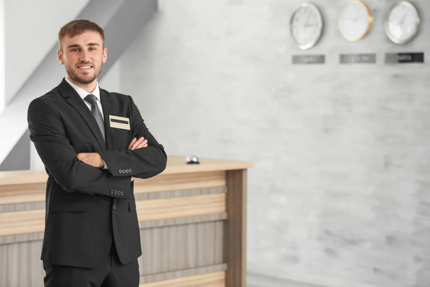 Male hotel receptionist at workplace - 写真・画像