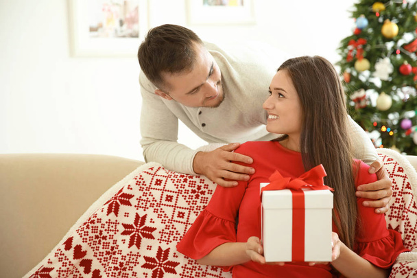 Young man making Christmas surprise for his girlfriend at home - Foto, imagen