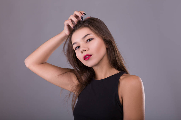 Brunette Woman with beauty makeup and red lips over gray background - 写真・画像