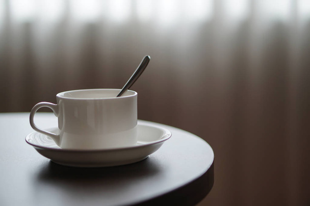 xícara de café branco na mesa por um sofá sofá no quarto do hotel
 - Foto, Imagem
