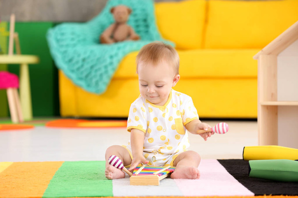 Cute little baby playing with musical instruments at home - Photo, image