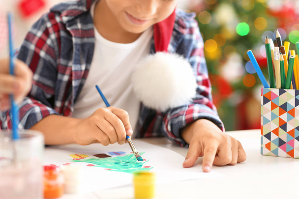かわいい男の子のテーブルでクリスマスのモミの木の絵画 - 写真・画像