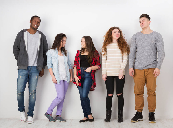 Ομάδα διαφορετικών μαθητών που στέκεται στη γραμμή σε εσωτερικούς χώρους - Φωτογραφία, εικόνα