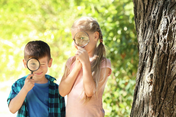 Милые маленькие дети с увеличительными очками на открытом воздухе
 - Фото, изображение