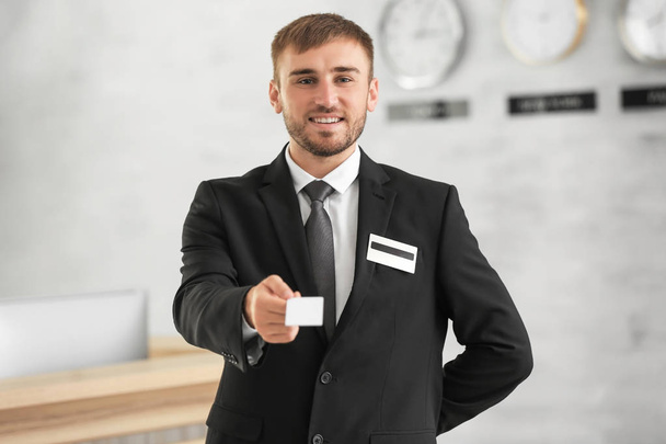 Male receptionist with card in hotel - Fotoğraf, Görsel