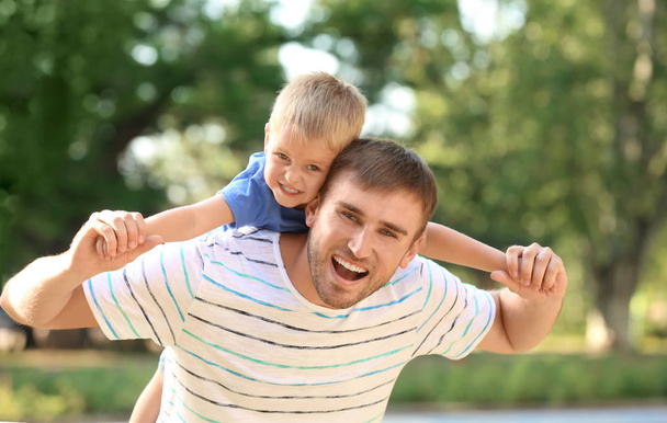 Homme heureux avec son fils dans le parc le jour ensoleillé
 - Photo, image