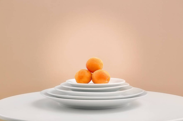 Ripe apricots on pile of plates  - 写真・画像